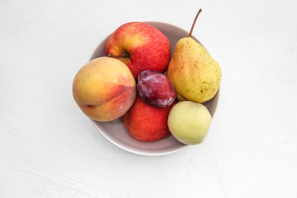 A simple bowl holding a few pieces of fruit